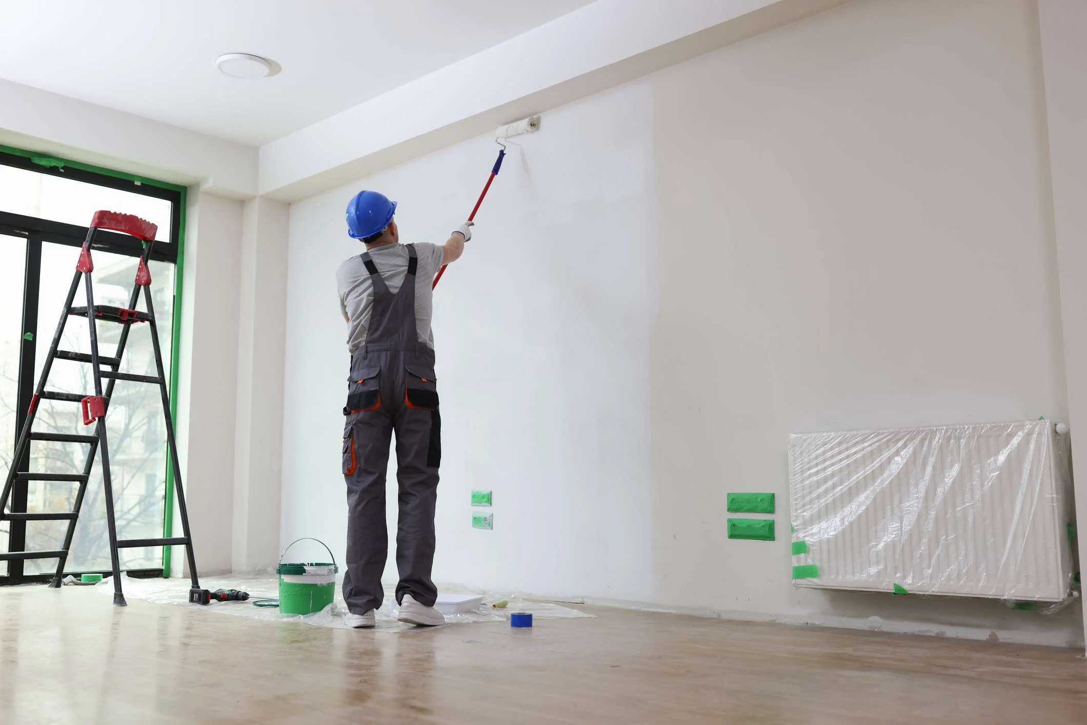 Skilled painter applying paint with precision on a prepared wall surface